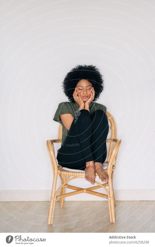 Black woman leaning chin on hands on timber chair appearance positive confident contemporary charismatic joy female barefoot black happy lean on hand afro