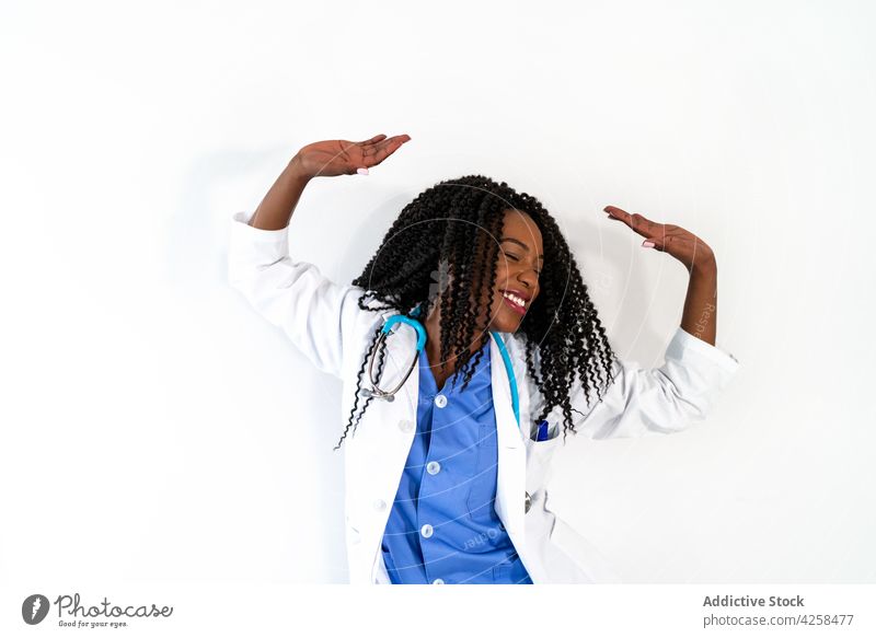 Black female doctor in medical uniform dancing in clinic woman dance move hospital active freestyle workplace office professional african american black ethnic