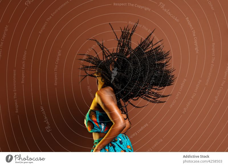 Black woman shaking hair during dance shake dynamic energy active perform motion action practice female move afro leisure hobby studio curly hair studio shot