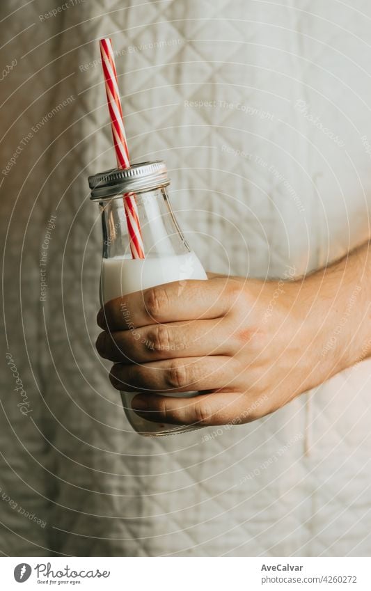 Hand holding a milkshake summer concept with copy space over a dark background person kid cream dairy man woman alone birthday colours crazy finger indoors