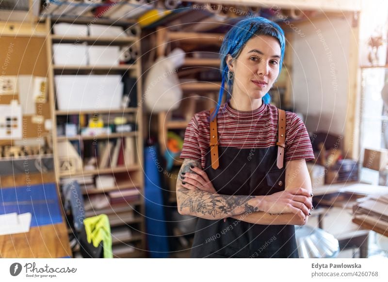 Confident young craftswoman in her workshop diy hipster colorful hair tattoos female owner profession service small business employee working technician