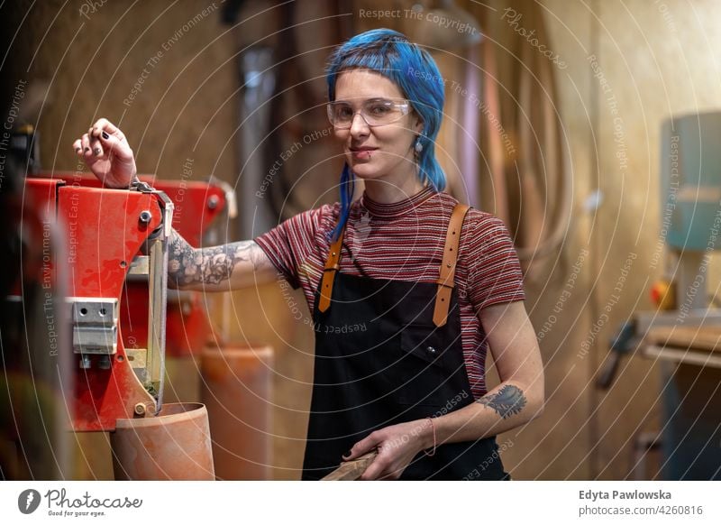 Female Carpenter In Her Workshop diy hipster colorful hair tattoos woman female owner profession service workshop small business employee working technician