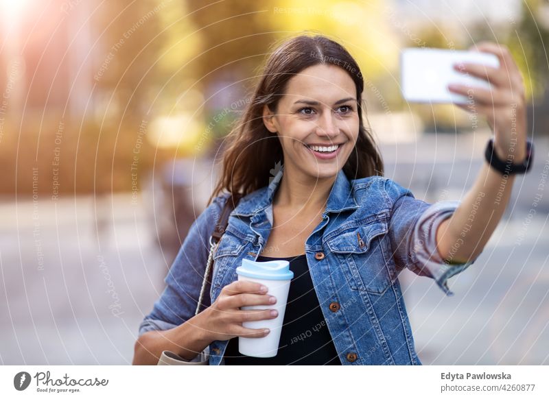 Young woman with smartphone and coffee in the city urban street active people young adult casual attractive female happy Caucasian enjoying one person beautiful