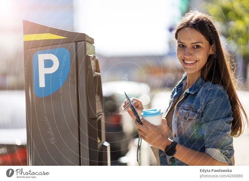 Woman paying for city parking urban street active people woman young adult casual attractive female happy Caucasian enjoying one person beautiful positivity