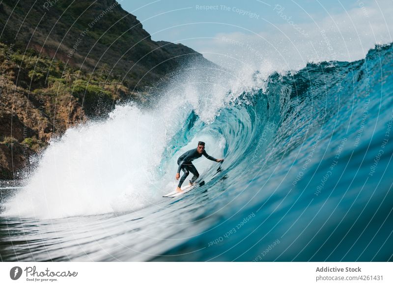Surfer practicing surfing on wavy sea with splashing water sportsman extreme practice adrenalin motion power wave mountain highland surfer energy dynamic flow