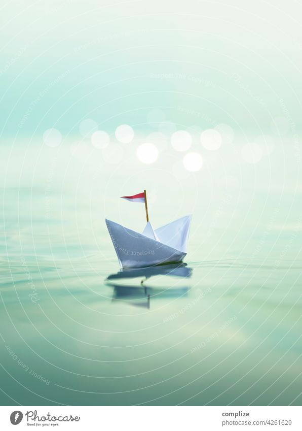Paper ship on the sea voyage travel Vacation mood Swell glossy Glimmer Sunset vacation bokeh paper boat Passenger ship Summer Sailing Waves Beach