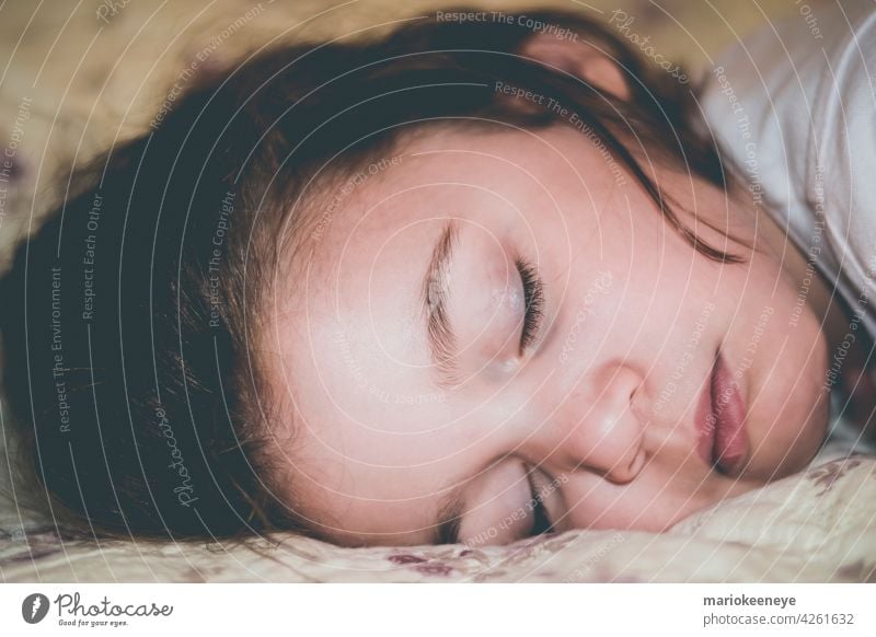 Close-up side view of a Caucasian little girl sleeping peacefully innocence innocent tenderness tranquility dreamy real people asleep one person tired bedroom