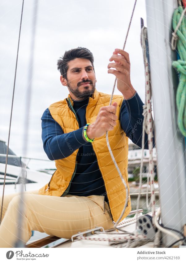 Man with rope on motorboat in city port man moor nautical transport river sky harbor urban lake yacht jacket apparel style cloudy casual alone water male