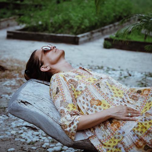 Woman in dress lying relaxed on a wooden lounger in a garden pretty Lie Couch Garden Dress vacation chill Summer voyage Vegetable bed plants Green Nature