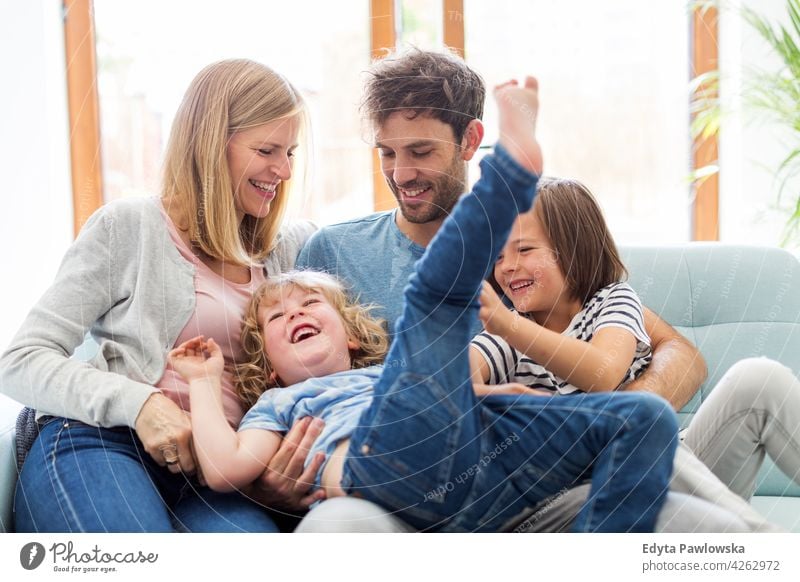 Happy young family having good time together man dad father woman female mother parents relatives son boy kids children relationship togetherness love people