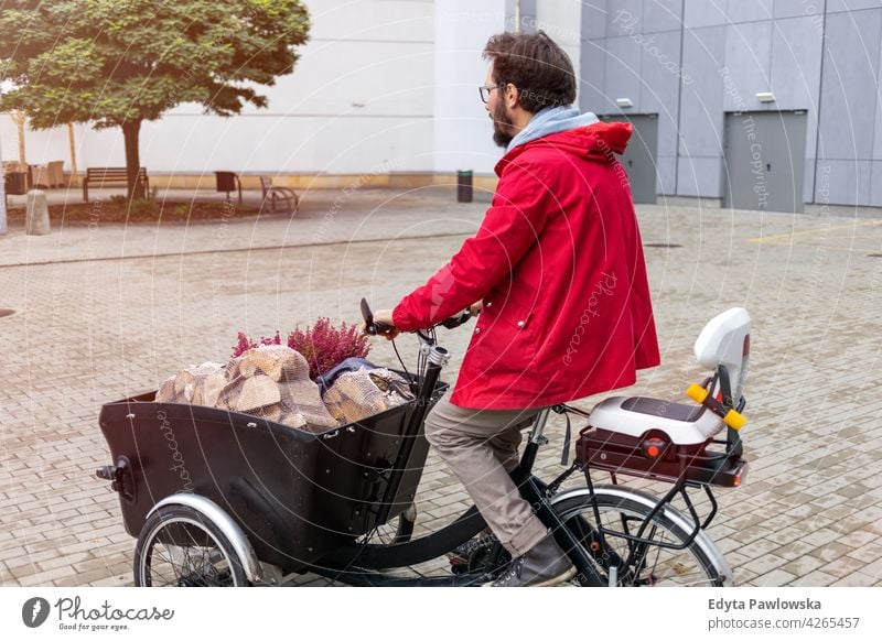 Man going back from shopping with a cargo bike carrying tricycle day healthy lifestyle active outdoors joy bicycle biking activity cyclist enjoying bike ride