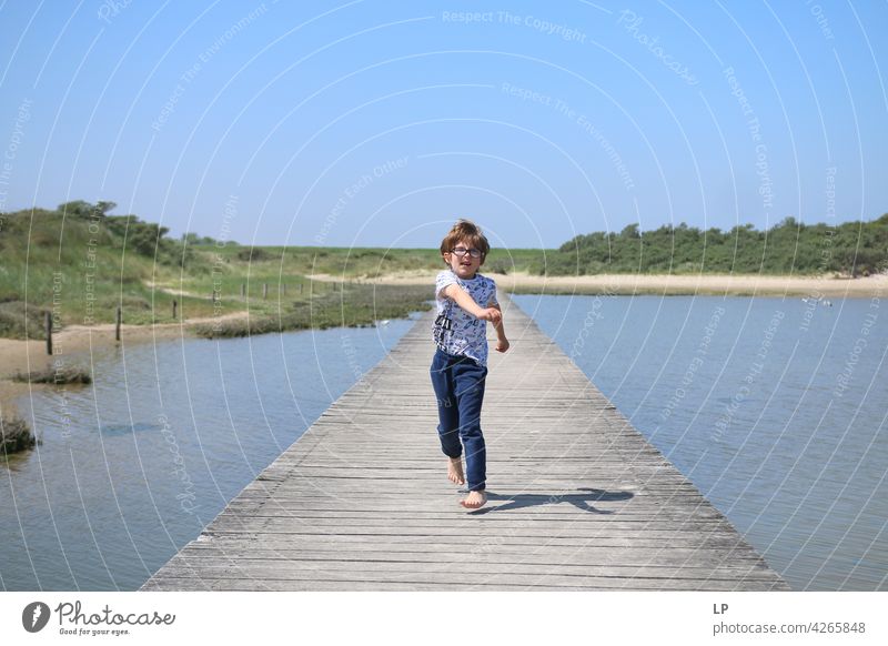 boy running on a wooden dock lonely Think Infancy Concern solitude pensive people abuse Expression Pain Fatigue Abstract Human being Exterior shot Education