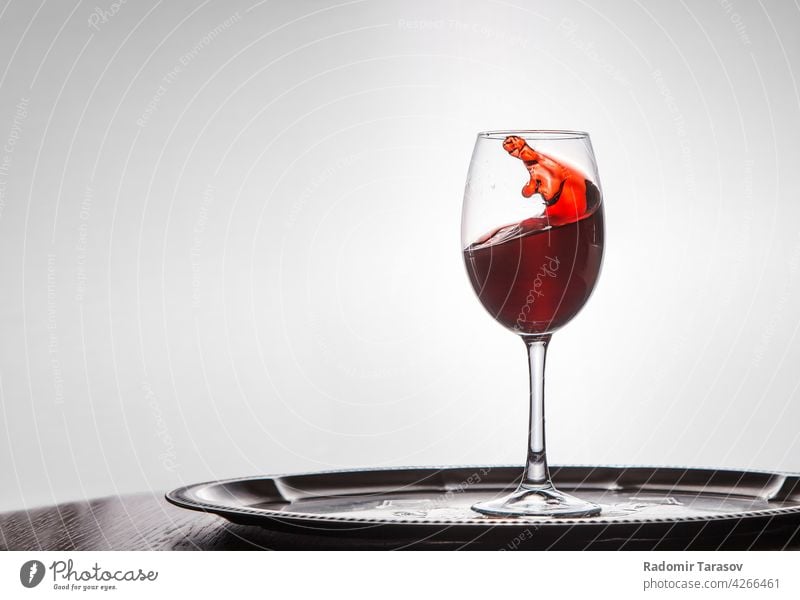 red wine spills out of a glass wineglass alcohol drink drop motion splash action beverage pour splashing white winery flow celebration background party object