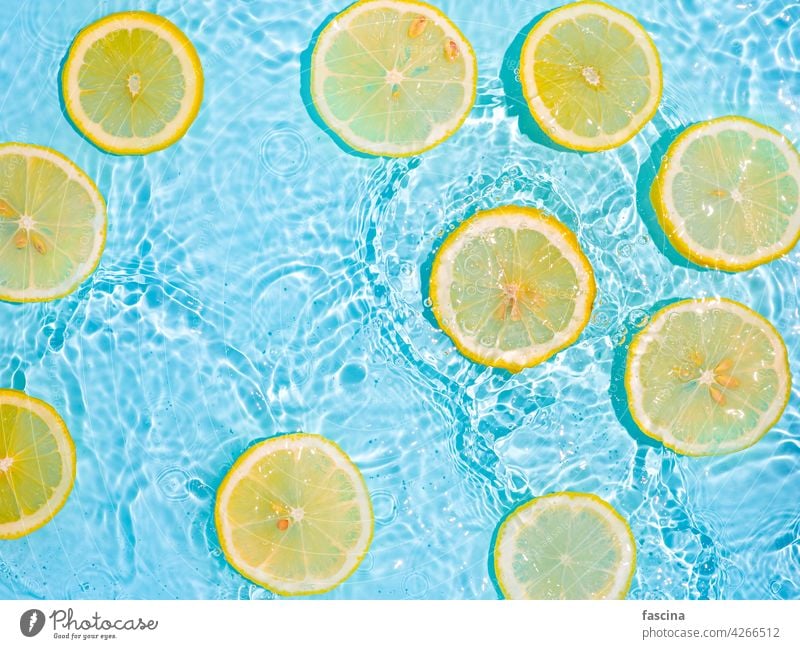 Lemon slices in clean transparent water, blue bg lemon citrus yellow splashing flat lay background copyscape flatlay splashes waves bubbles underwater surface