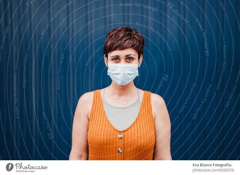 Caucasian woman outdoors wearing face mask. Pandemic during corona virus social distance concept. Woman Face mask portrait City urban Outdoors Casual clothing
