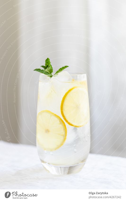 Cold citrus water. drink cold lemonade ice mint summer glass refreshment perspiration beverage white table minimal cocktail background cool selective focus