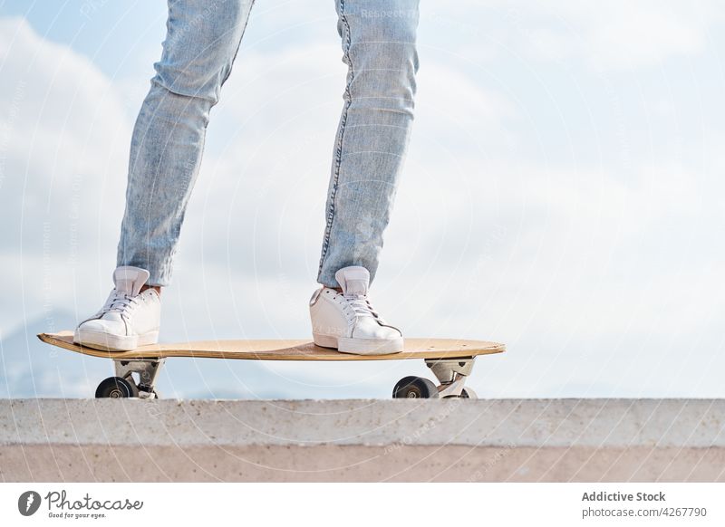 Male skateboarder riding on embankment in tropical town man activity skill hobby ride balance leisure male free time urban active casual cool ability park