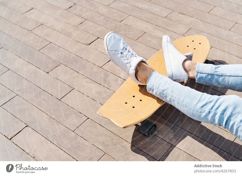 Male skateboarder in park in sunlight man chill hobby leisure free time sport pastime urban cool male relax activity sneakers casual footwear jeans street rest