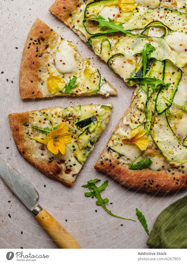 Delicious pizza with zucchini slices on gray background cheese arugula sesame food lunch seasoning baked delicious vegetable knife squash flower seed black
