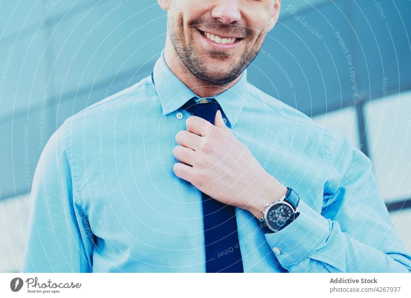 Crop content businessman in wristwatch in town executive well dressed independent style tie masculine city smile macho brutal shirt lifestyle formal wear blue