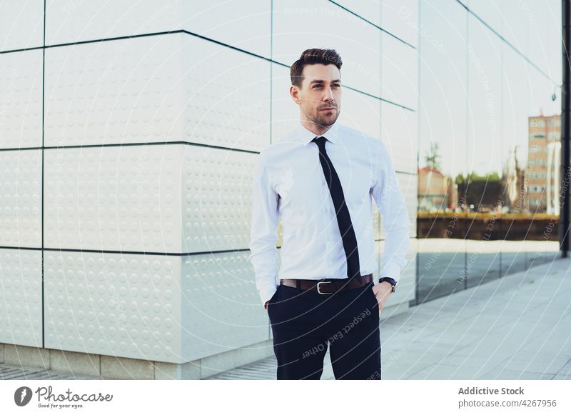 Businessman standing against city building businessman style formal lifestyle executive well dressed urban architecture contemporary entrepreneur male town