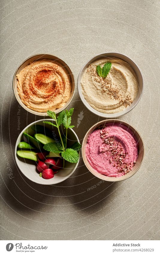 Bowl with colorful hummus served on table with fresh veggies cucumber radish meal food assorted bowl nutrition vegetable organic gourmet appetizer recipe