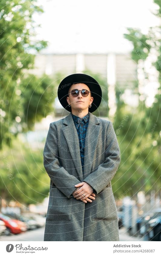 Queer in stylish outerwear and sunglasses outdoors transgender person style fashion individuality accept identity tattoo portrait queer androgynous sincere