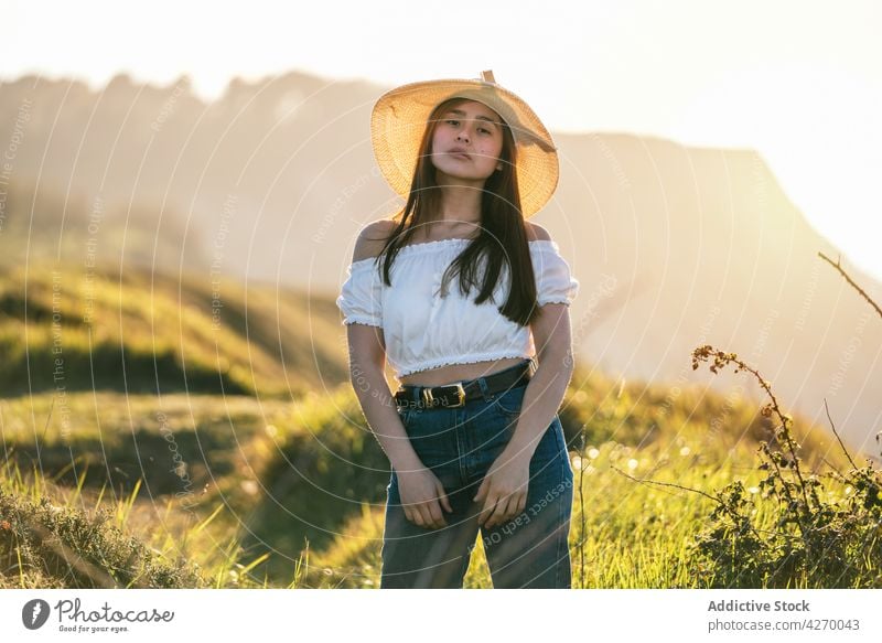Woman standing on verdant grassy countryside woman lawn dreamy peaceful summer style sensitive nature serene meadow trendy appearance tranquil jeans field calm