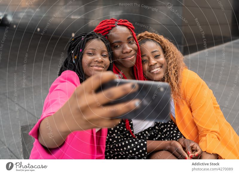 Black stylish girlfriends taking selfie on smartphone women best friend style using capture together friendship meeting female mobile take photo toothy smile