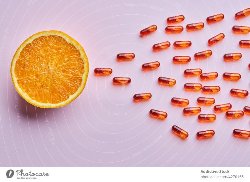 Composition of ripe oranges near scattered pills drug fruit composition medication capsule supplement dose cure remedy vitamin pharmacy health care concept