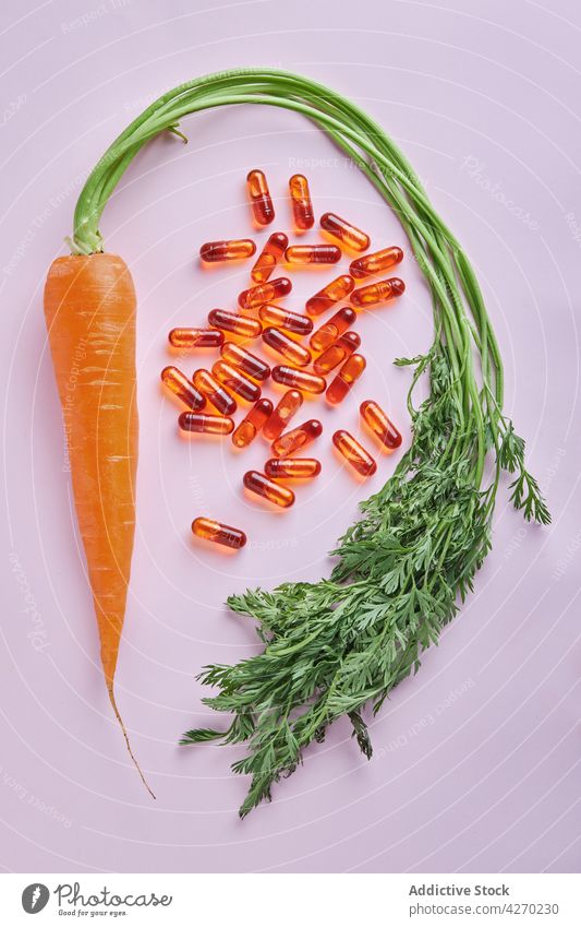Vitamin pills scattered near ripe carrots vitamin healthy organic vegetable fruit composition orange food natural fresh nutrition citrus juice tasty colorful
