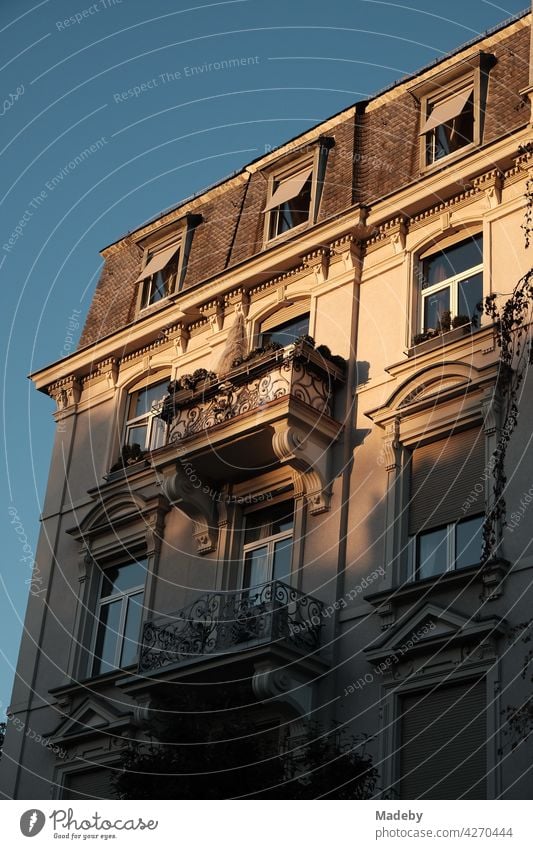 Balconies at a beautiful restored old building in front of a blue sky in the light of the setting sun in the Westend of Frankfurt am Main in Hesse, Germany