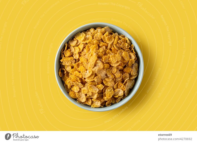Corn flakes in a blue bowl american breakfast brunch cereal corn crispy crunchy dairy diet dry eat energy food healthy snack table yellow