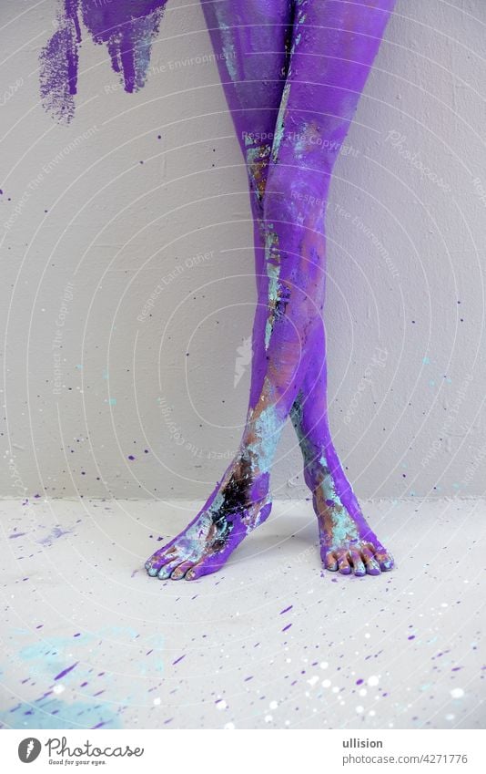 beautiful sexy legs and feet on tiptoe of a young artistically abstract painted woman, ballerina with white, blue and purple paint. Creative body art painting.