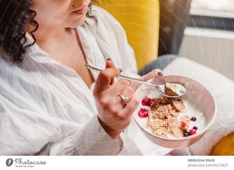 Woman eating healthy breakfast from bowl woman cereal berry yogurt meal morning nutrition female delicious diet food yummy tasty healthy food portion sweet
