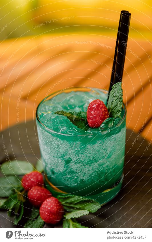 Cooling cocktail with raspberry and mint leaves curacao liqueur gin passion fruit lemon juice serve glass cold beverage refreshment exotic mix alcohol tropical