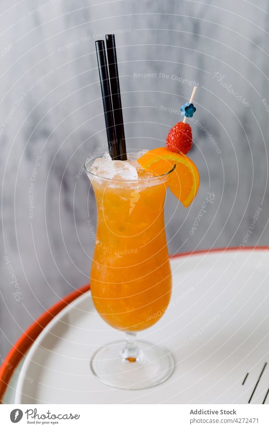 Glass of cocktail served with strawberry and slice of orange sex on beach liqueur vodka juice alcohol cold glass liquor bar citrus fruit drink beverage
