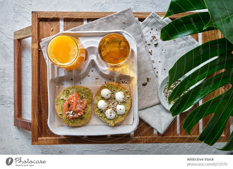 Healthy breakfast with avocado toasts and beverages served on table in tropical resort salmon juice tea appetizing healthy food burrata drink delicious fresh