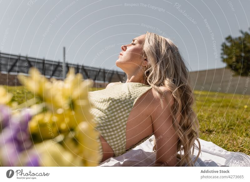 Woman lying on plaid in sunny day woman chill relax nature countryside lawn carefree peaceful flower female eyes closed rural grassy serene tranquil plant quiet