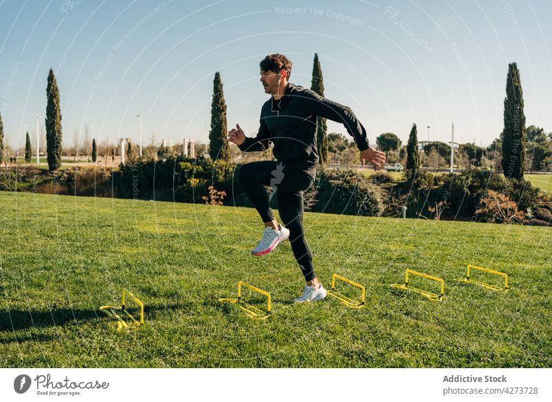 Active sportsman jumping during cardio training in park workout activity exercise energy dynamic practice sneakers leap wellbeing vitality healthy lifestyle