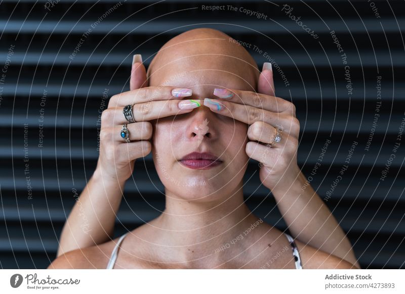 Anonymous lady covering eyes of hairless woman on street women cover eyes alopecia calm together friend disease bald problem serious daytime building style