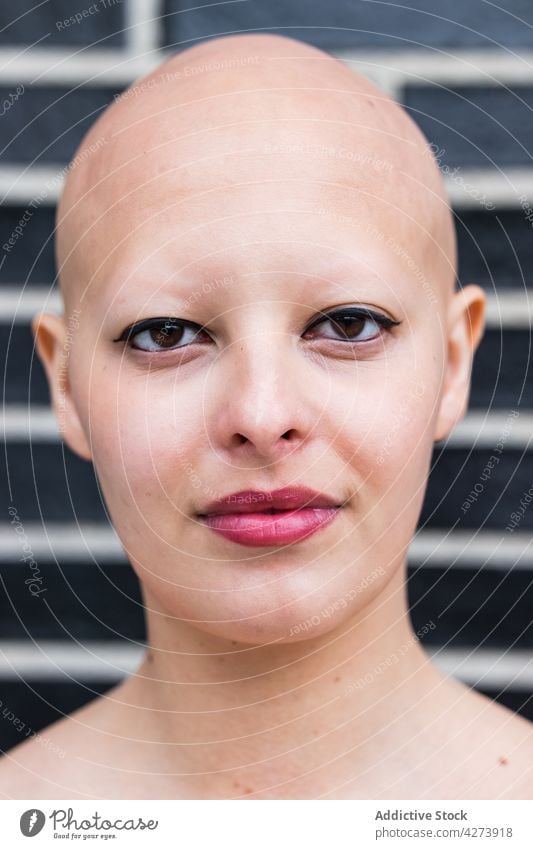 Hairless woman with makeup looking at camera on street bald alopecia model disease personality appearance confident portrait calm perfect individuality style