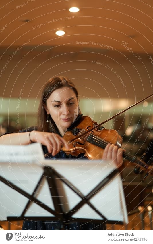 Female violinist performing classical music in hall woman musician play rehearsal instrument skill melody sound talent studio acoustic audio tune artist