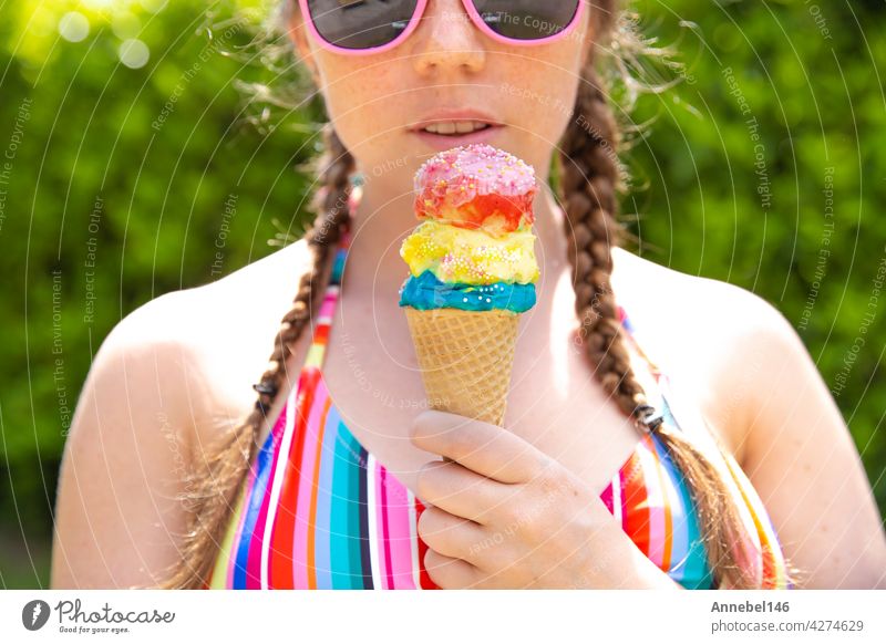 Young teenage girl eating icecream cone wearing pink sunglasses and braids on hot summer day child food person kid chocolate face human licking life lifestyle
