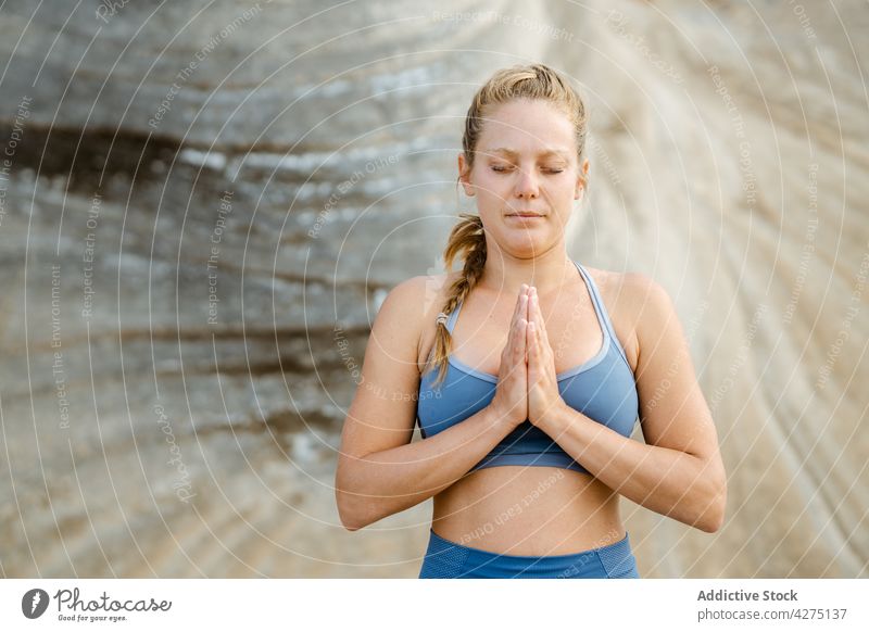 Concentrated woman meditating with praying hands outdoors meditate yoga concentrate eyes closed stress relief zen harmony portrait practice wellness vitality