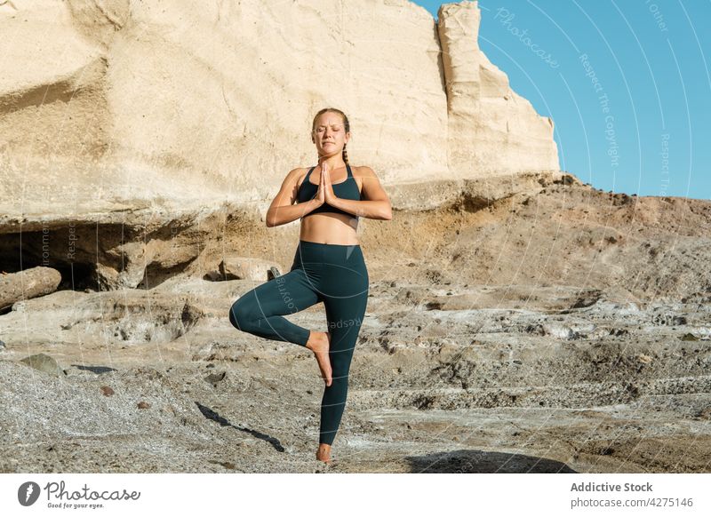 Concentrated woman on tree pose outdoors meditate yoga concentrate stress relief vrksasana zen practice wellness eyes closed vitality healthy lifestyle
