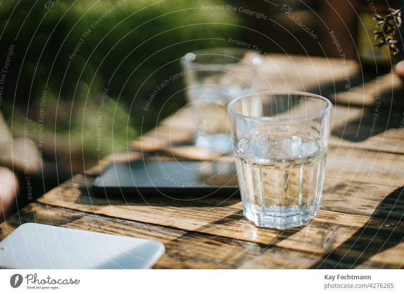 glasses of fresh water on table afternoon beverage cellphone desk drink food and drink garden health heat horizontal hydrate leisure liquid negative space