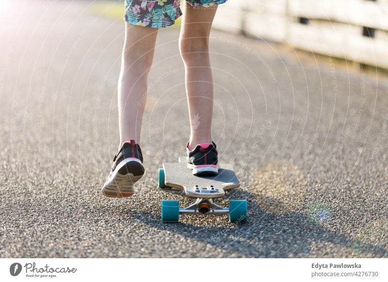 Little girl skateboarding in campsite Texel sea camping family people girls children kids Dutch Europe Holland Netherlands Outdoor summer day park active fun