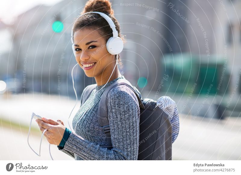 Happy young woman listening music in headphones in the city outdoors day positivity confident carefree people young adult casual beautiful attractive female