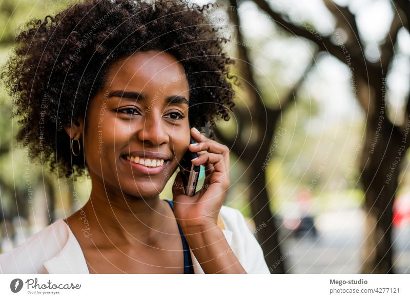 Business woman talking on the phone outdoors. afro business mobile modern style brunette gadget positive concept connection application sms texting